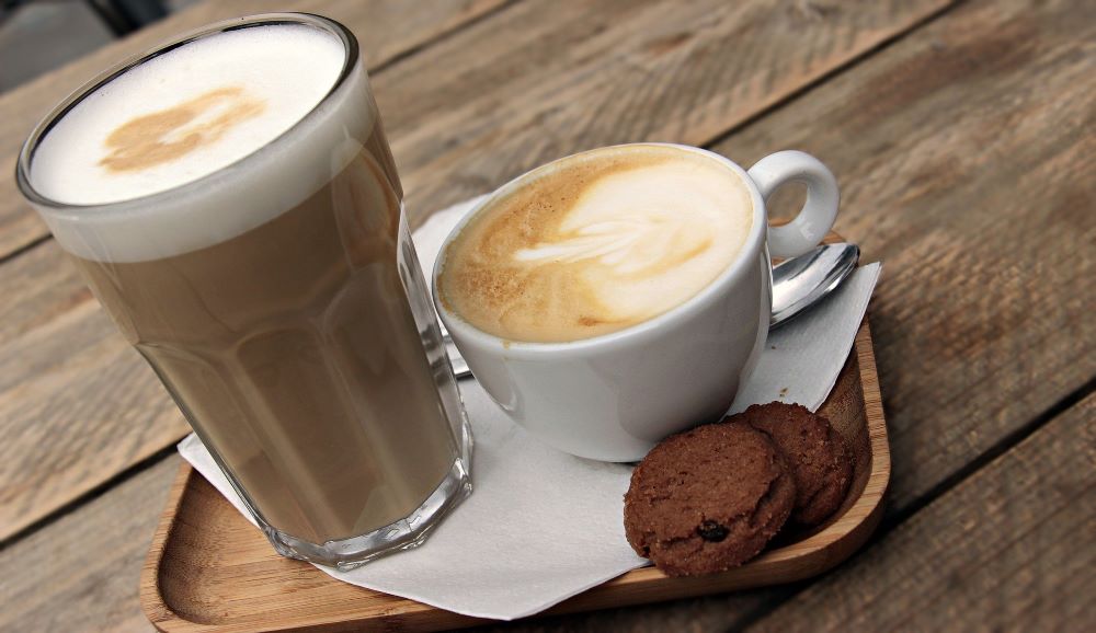 coffee drinks and cookies on a counter