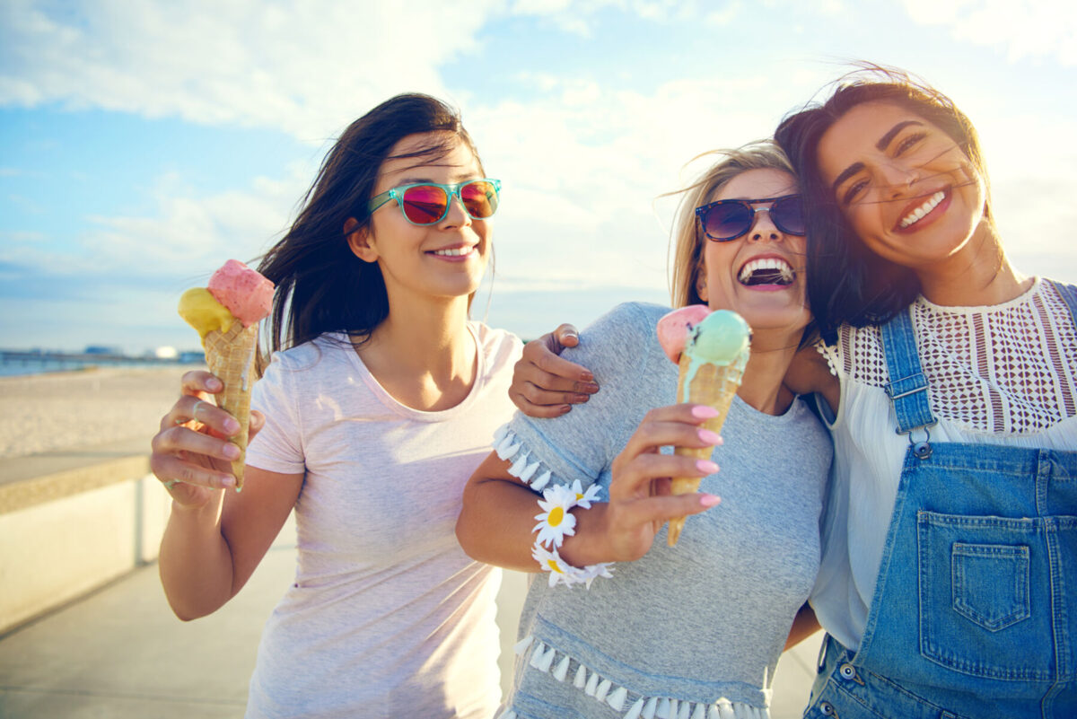 Women eating ice cream on the beach.