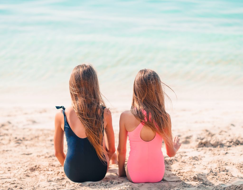 little girls sitting on the beach