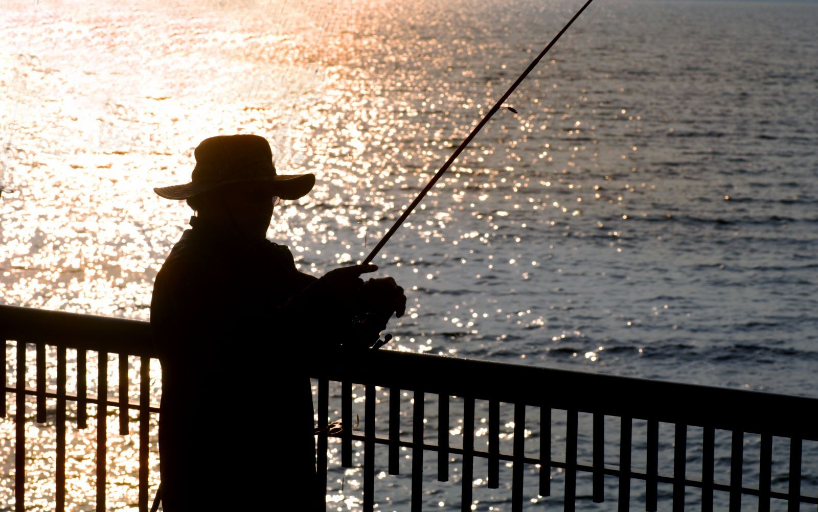 man fishing off a pier